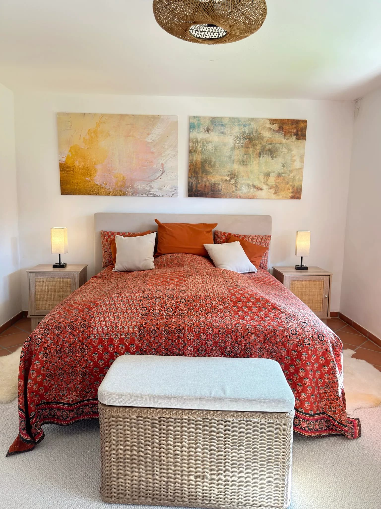Schlafzimmer mit Boxspringbett, Nachttisch und warmem Licht.